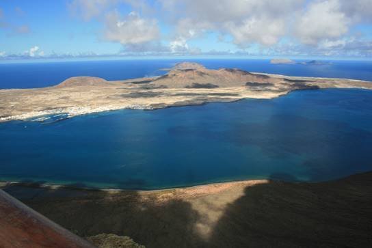 La Graciosan näkymä Lanzaroten näköalapaikalta. Etualalla Caleta del Sebo -satama ja takana Punainen vuori. La Graciosan näkymä Lanzaroten näköalapaikalta. Etualalla Caleta del Sebo -satama ja takana Punainen vuori.