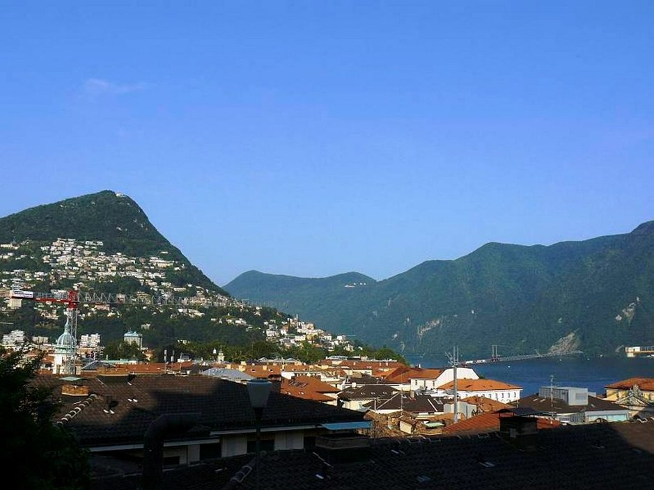 Lugano on kaupunki vuorten syleilyssä. Lugano on kaupunki vuorten syleilyssä.