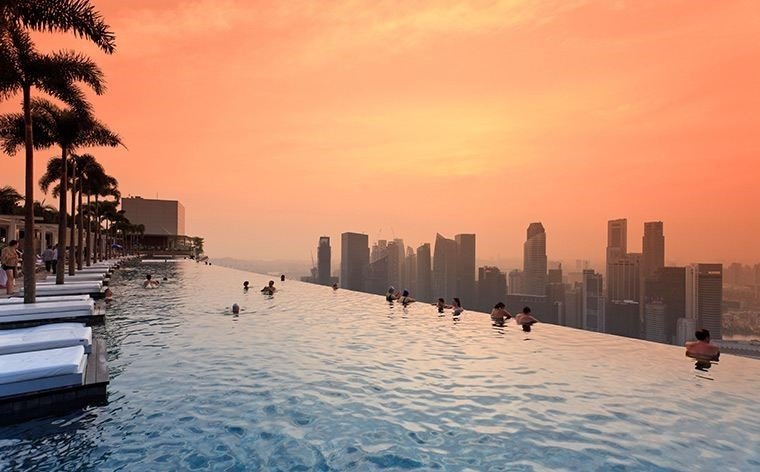 MARINA BAY SANDS, SINGAPORE
Hotelli Marina Bay Sandsin katolla voit uida 150-metrisessä äärettömässä altaassa. Päästä päähän mitattuna altaan pituus vastaa reilusti yli jalkapallokentän mittaista matkaa, joten tila ei hevillä pääse loppumaan kesken. Näkyvien reunojen puute luo illuusion uimisesta pilvenpiirtäjien välillä, joten saatat hetken tuntea olevasi maailman huipulla. Kattauksen kruunaa Singaporen uskomaton suurkaupunkimaisema, jonka vain hotellin asukkaat pääsevät näkemään.
MARINA BAY SANDS, SINGAPORE
Hotelli Marina Bay Sandsin katolla voit uida 150-metrisessä äärettömässä altaassa. Päästä päähän mitattuna altaan pituus vastaa reilusti yli jalkapallokentän mittaista matkaa, joten tila ei hevillä pääse loppumaan kesken. Näkyvien reunojen puute luo illuusion uimisesta pilvenpiirtäjien välillä, joten saatat hetken tuntea olevasi maailman huipulla. Kattauksen kruunaa Singaporen uskomaton suurkaupunkimaisema, jonka vain hotellin asukkaat pääsevät näkemään.